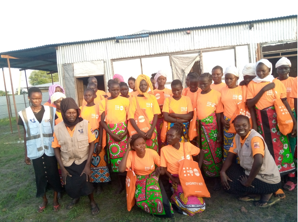 Group of Women and girls pose for a photo with WOCO’s volunteers after receiving dignity kits in Kodok- Fashoda County- Photo courtesy- Okuna Joe Albert Communications and Advocacy Officer